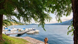 A lakeside dock with boats, a wooden pier, and a grassy area.