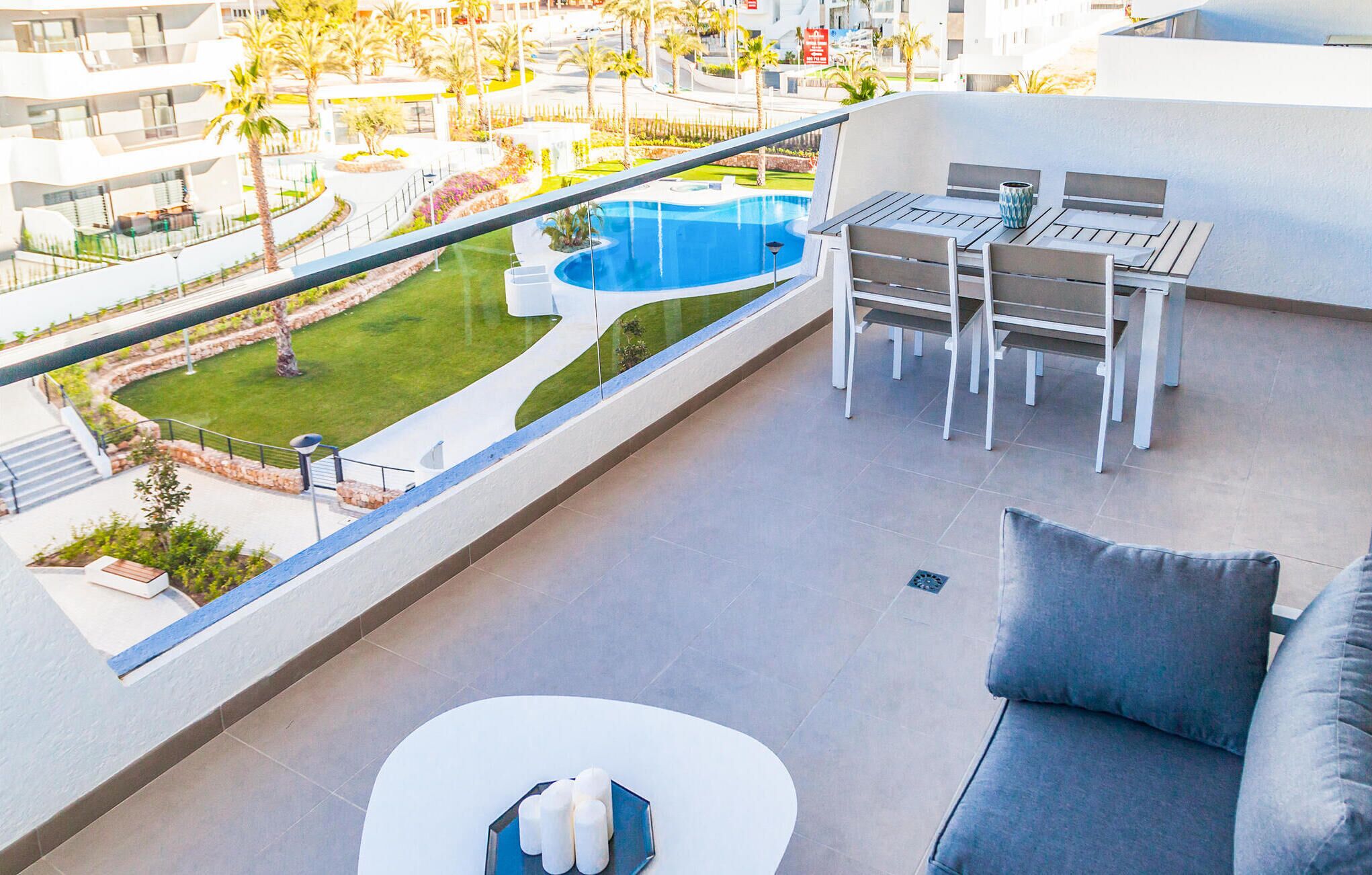 A balcony with a pool view, outdoor seating, and a modern design.