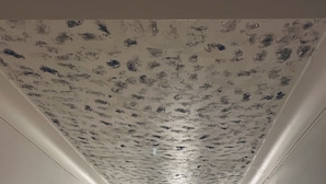 A narrow hallway with white walls and a textured ceiling. A door at the end leads to a room with a visible light fixture. - 2-bed Apartment (Kingston Upon Thames)