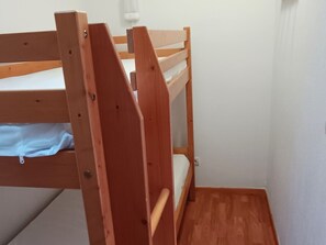A bunk bed with a wooden frame and a mattress. - Superdévoluy Rental: Cosy Duplex 6 pers, Pets allowed (Le Dévoluy)