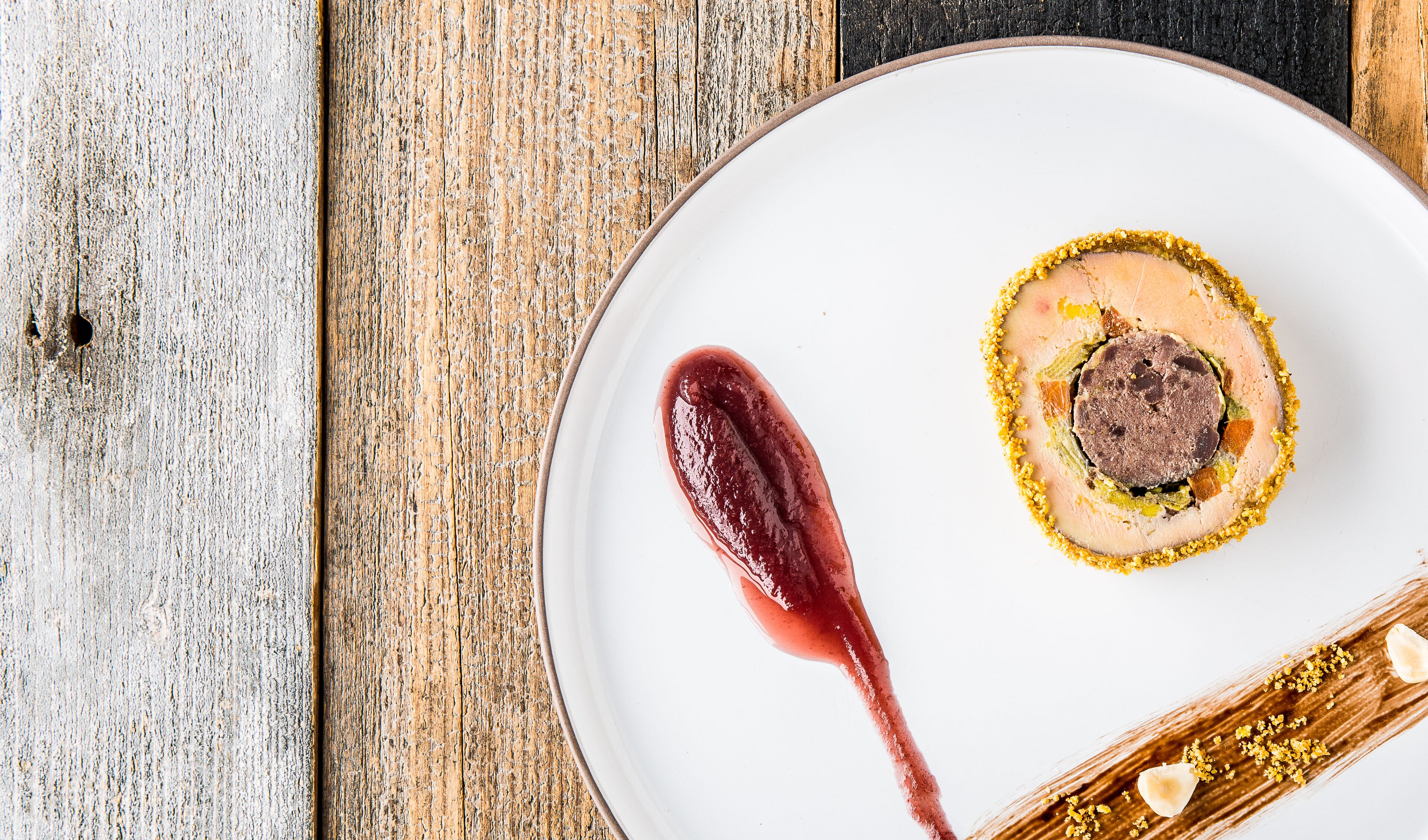 Une assiette contenant un dessert, posée sur une table en bois.