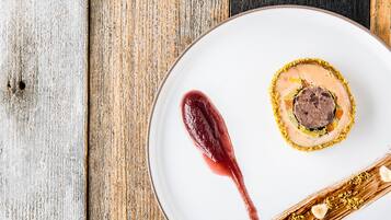 Une assiette contenant un dessert, posée sur une table en bois.