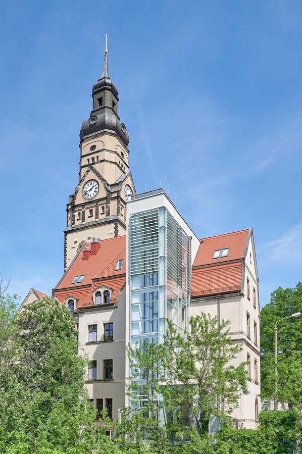 A historic building with a clock tower and modern glass facade. - Inklusionshotel PHILIPPUS Leipzig (Leipzig)