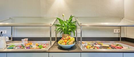 Un buffet proposant une variété de plats et agrémenté d’une plante centrale.