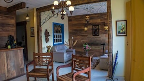 Una sala de estar acogedora con muebles de madera, una chimenea y apliques decorativos.