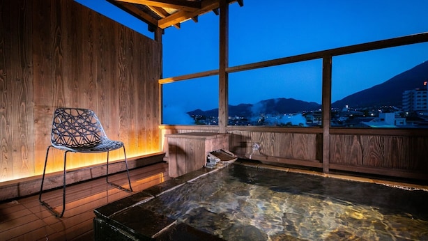 Un intérieur en bois offrant une vue dégagée sur un paysage montagneux au crépuscule.