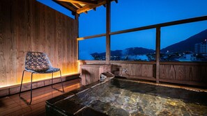 A wooden interior with a clear view of a mountainous landscape at dusk.