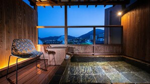 Une pièce en bois avec une grande fenêtre, une chaise et un jacuzzi.