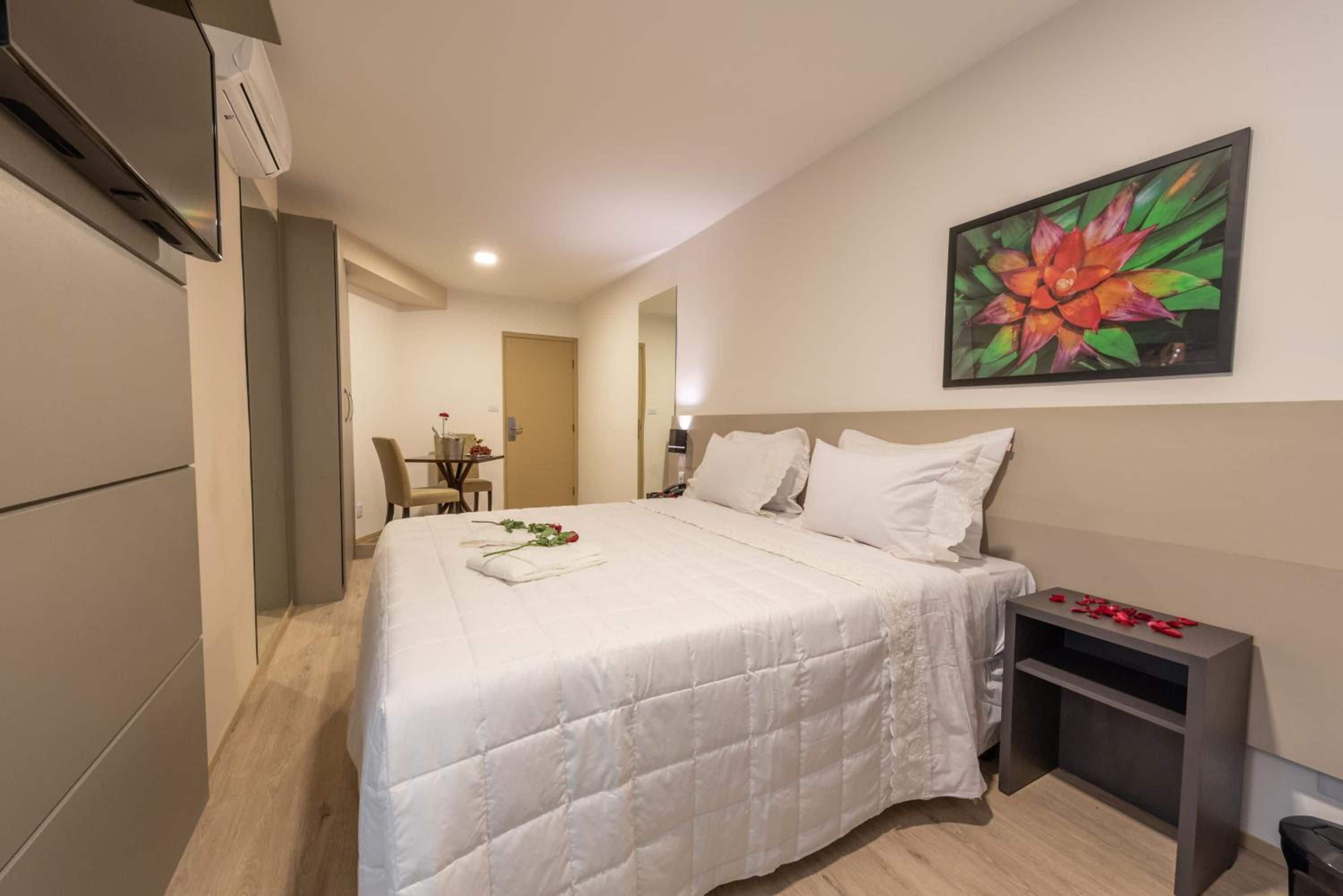 A hotel room with a bed, a desk, and a chair.