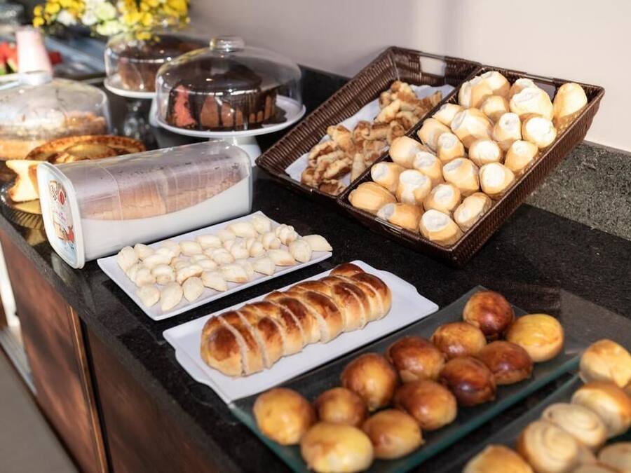 A buffet with various baked goods including bread, pastries, and rolls.