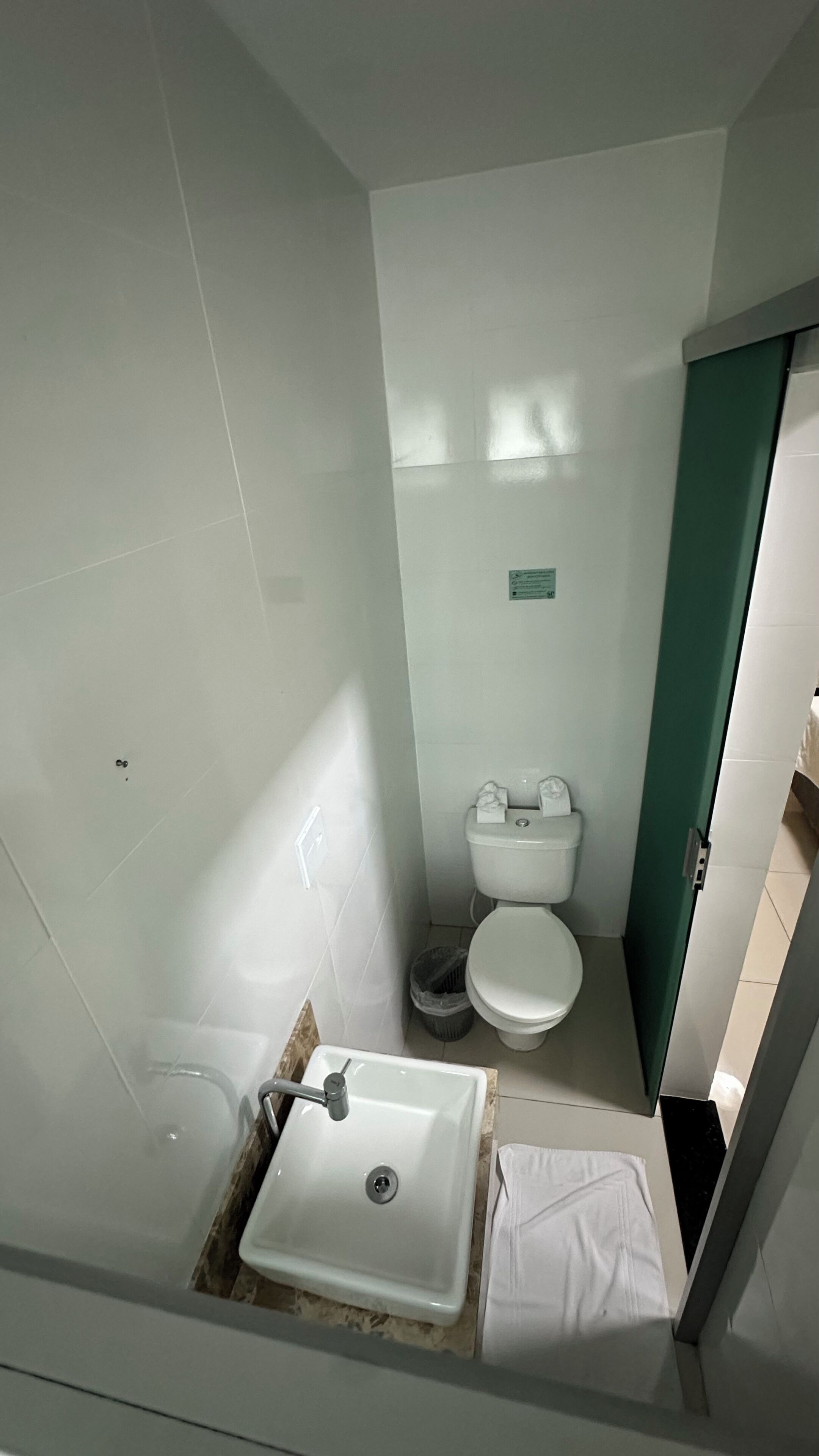 Un bagno con lavandino, servizi igienici e zona doccia, tutti in bianco.