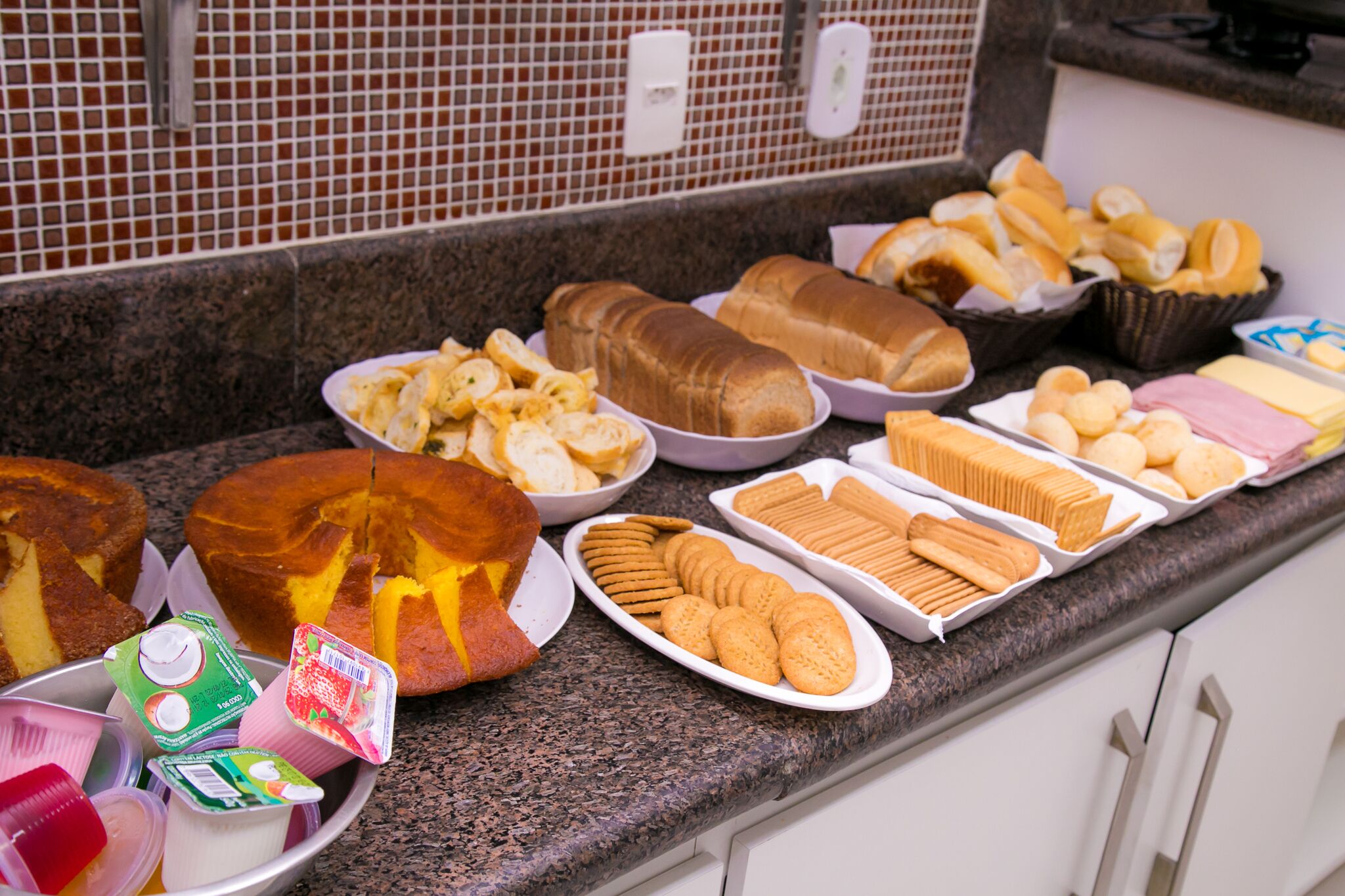 A buffet with various breads, pastries, and dairy products.
