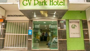 The entrance of GV Park Hotel with a glass door, a metal gate, and a sign above the door. - GV Park Hotel (Governador Valadares)