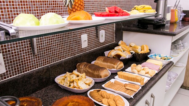 A buffet with various food items including fruits, bread, and pastries. - GV Park Hotel (Governador Valadares)
