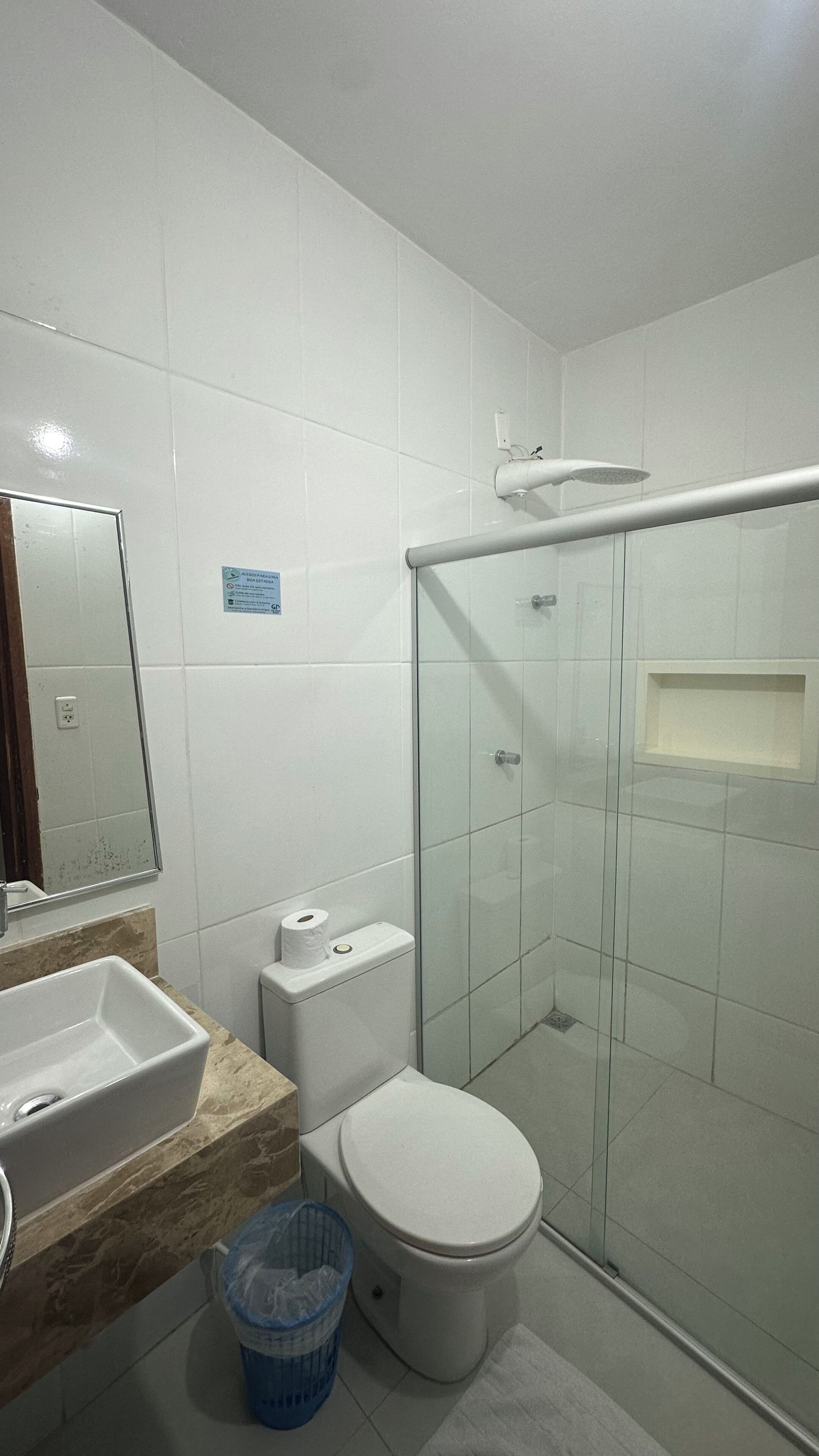 A bathroom with a toilet, sink, and shower.