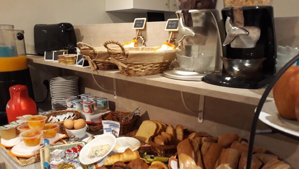 A breakfast buffet with various food items, including pastries, bread, and beverages. - La Caravelle (Riom)