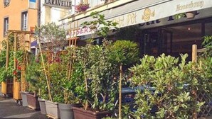 A hotel named "Hotel La Garavelle" with a signboard, potted plants, and a wooden cart. - La Caravelle (Riom)
