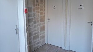 A hallway with two white doors, each marked with a number. - La Caravelle (Riom)