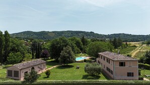 A villa with a swimming pool, surrounded by lush greenery and hills in the background. - Apartment BERRIES (Agriturismo Il Corniolo) (CORCIANO)