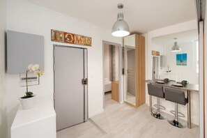 Une salle de bain moderne équipée d’une douche, de toilettes et d’un lavabo. Un miroir est placé au-dessus du lavabo et un porte-serviettes est fixé au mur.