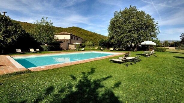 A swimming pool with lounge chairs and a gazebo, surrounded by a well-maintained lawn and trees. - Apartment GRAPE (Agriturismo Il Corniolo) (CORCIANO)