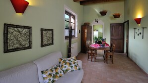 A cozy dining area with a table set for two, a wooden ceiling, and a light-colored wall. - Apartment GRAPE (Agriturismo Il Corniolo) (CORCIANO)