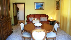 Comedor con una mesa redonda, sillas, un sofá y un aparador.