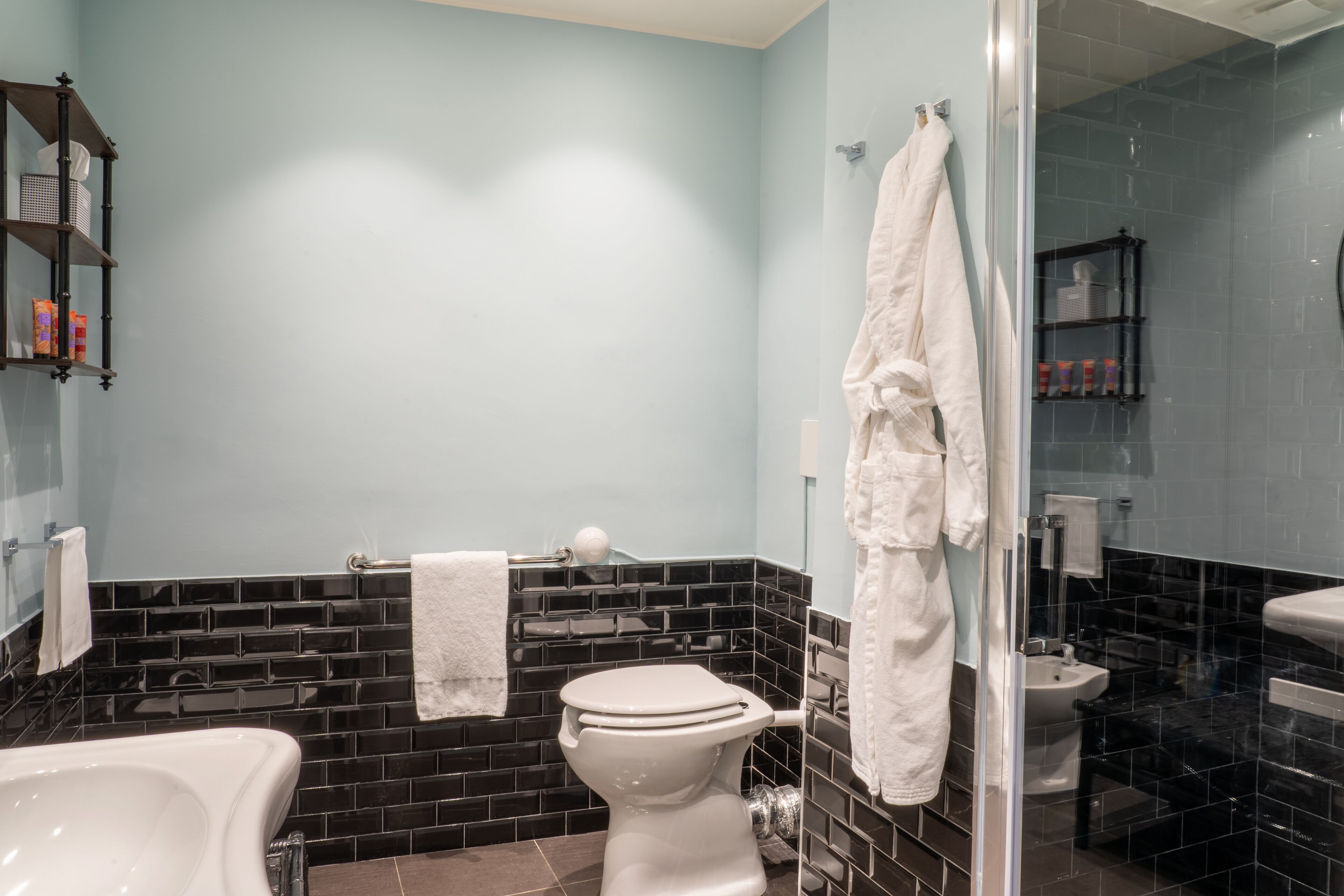 Un baño moderno con bañera, inodoro y zona de ducha con mampara de vidrio.