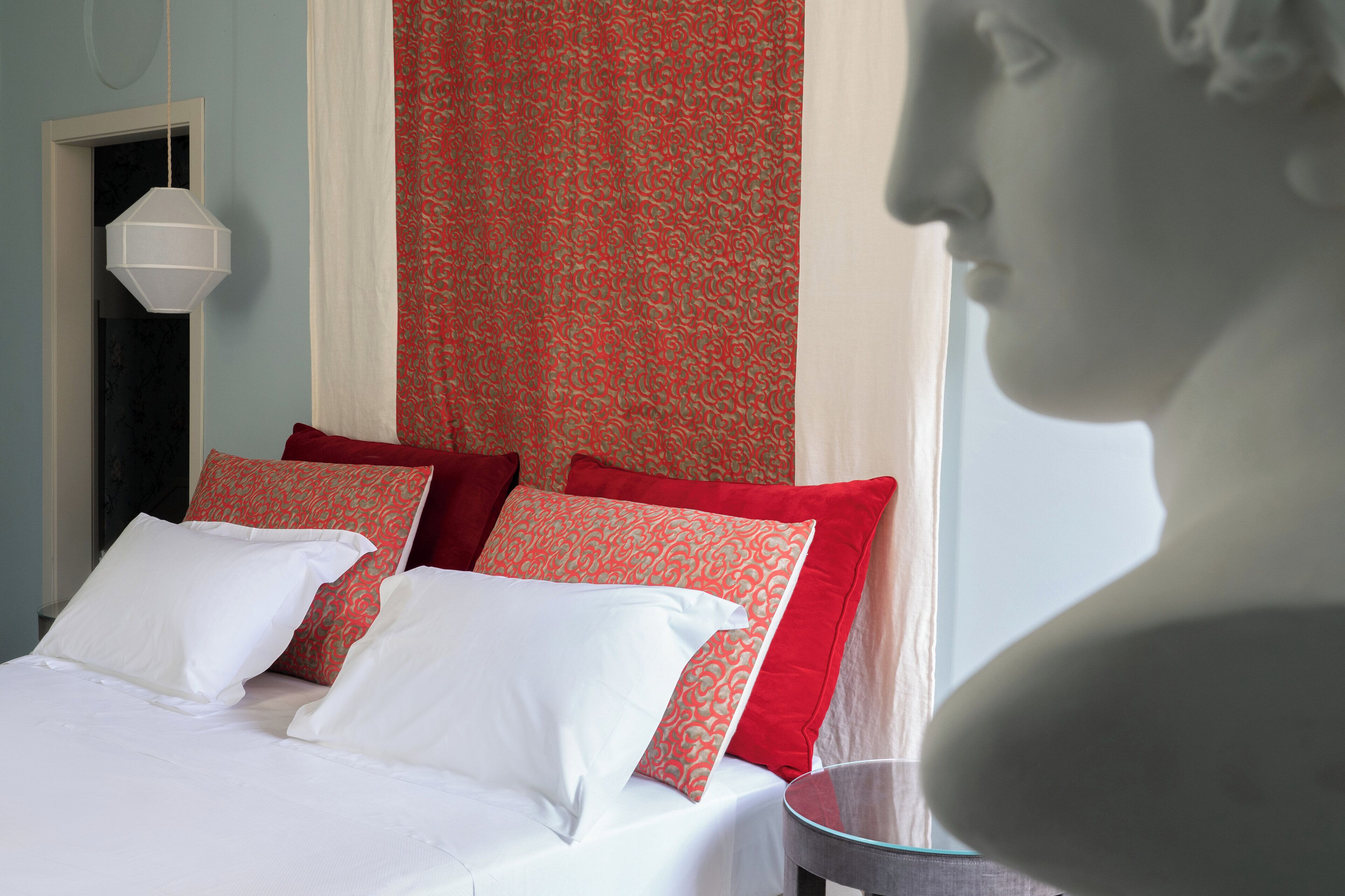 A bedroom with a bed, pillows, and a nightstand.
