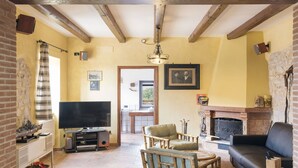 A cozy living room with a fireplace, a television, and comfortable seating. - Wonderful private villa for 6 people with private pool, WIFI, TV, terrace and pets allowed (Santa Maria)