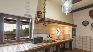 A kitchen with a wooden countertop, a gas stove, a built-in oven, and a hanging light fixture. - Wonderful private villa for 6 people with private pool, WIFI, TV, terrace and pets allowed (Santa Maria)