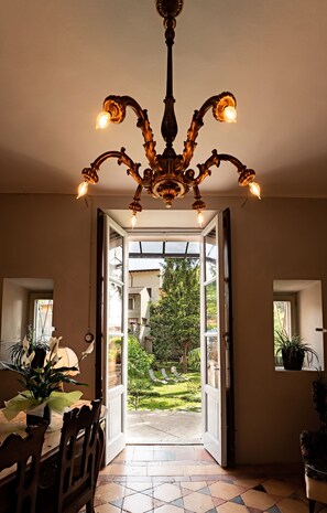 Una porta oberta que dona a un jardí amb vistes a un arbre i una casa.