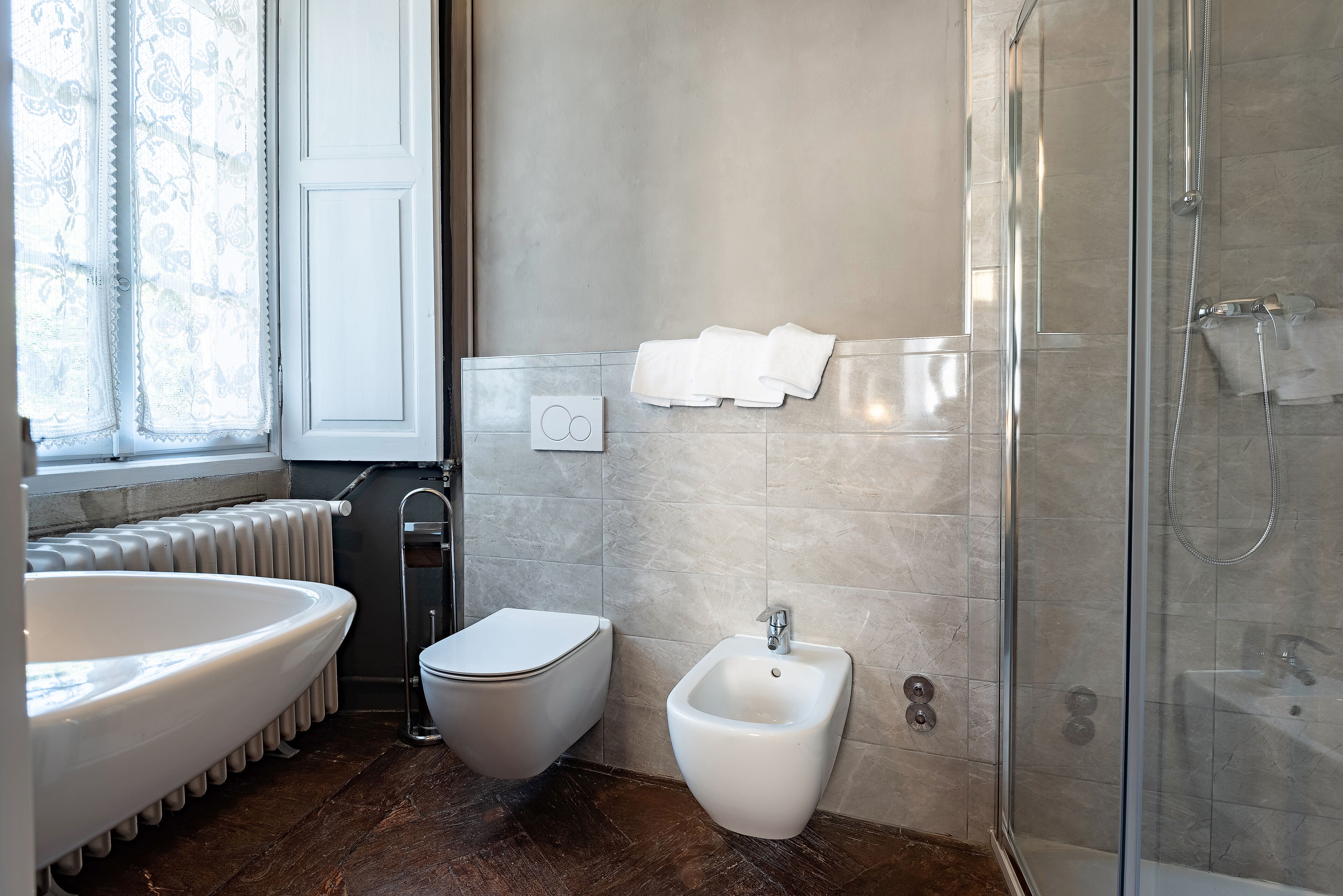 Un bagno moderno con una vasca da bagno spaziosa, un water, un bidet e una cabina doccia in vetro.
