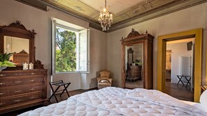 Un dormitorio con una cama grande, un aparador de madera y un espejo.