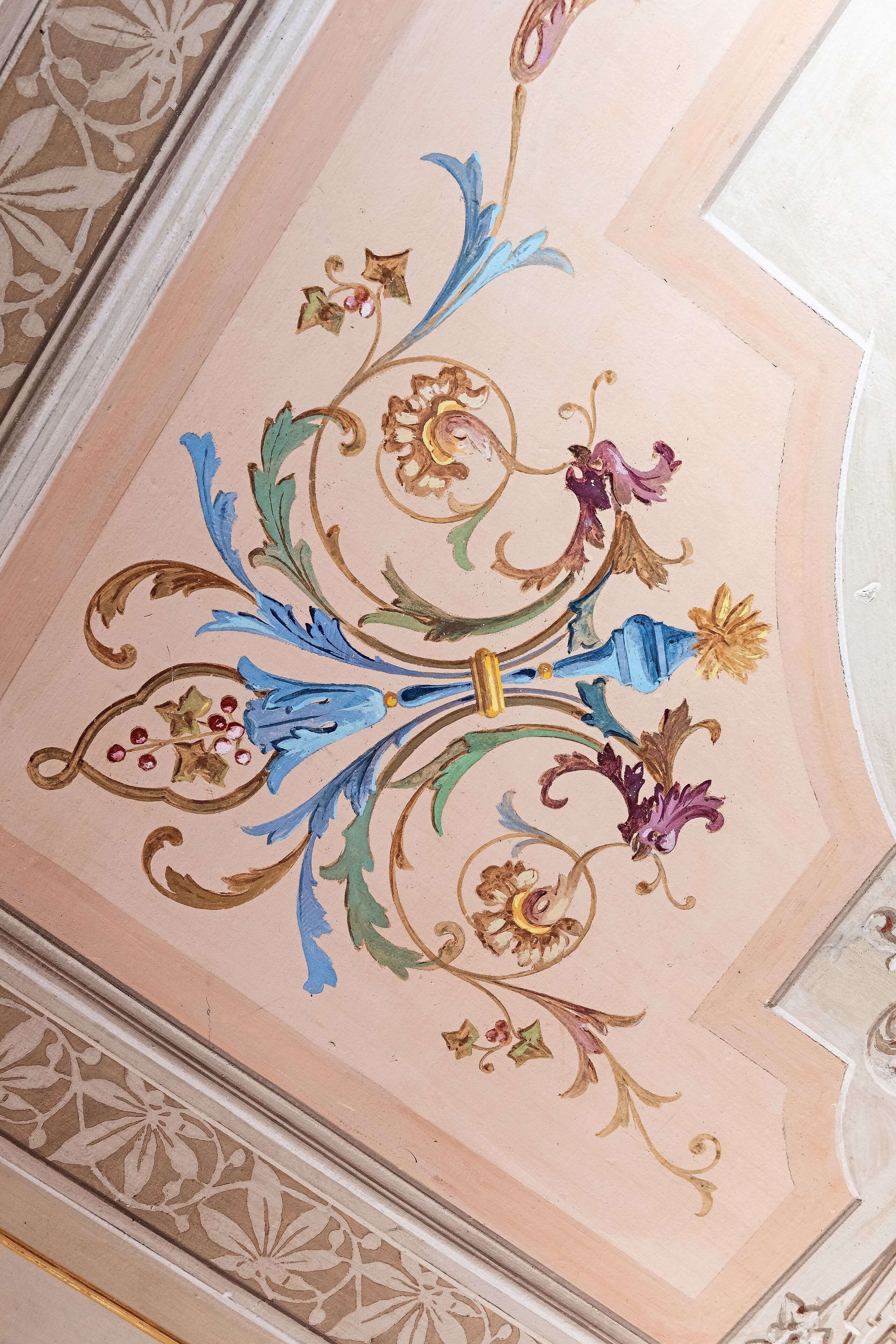 Un plafond orné de motifs floraux et de volutes complexes.