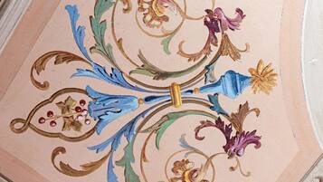 Un plafond orné de motifs floraux et de volutes complexes.