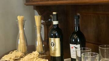 A wooden cabinet with two wine bottles and glasses on a table.