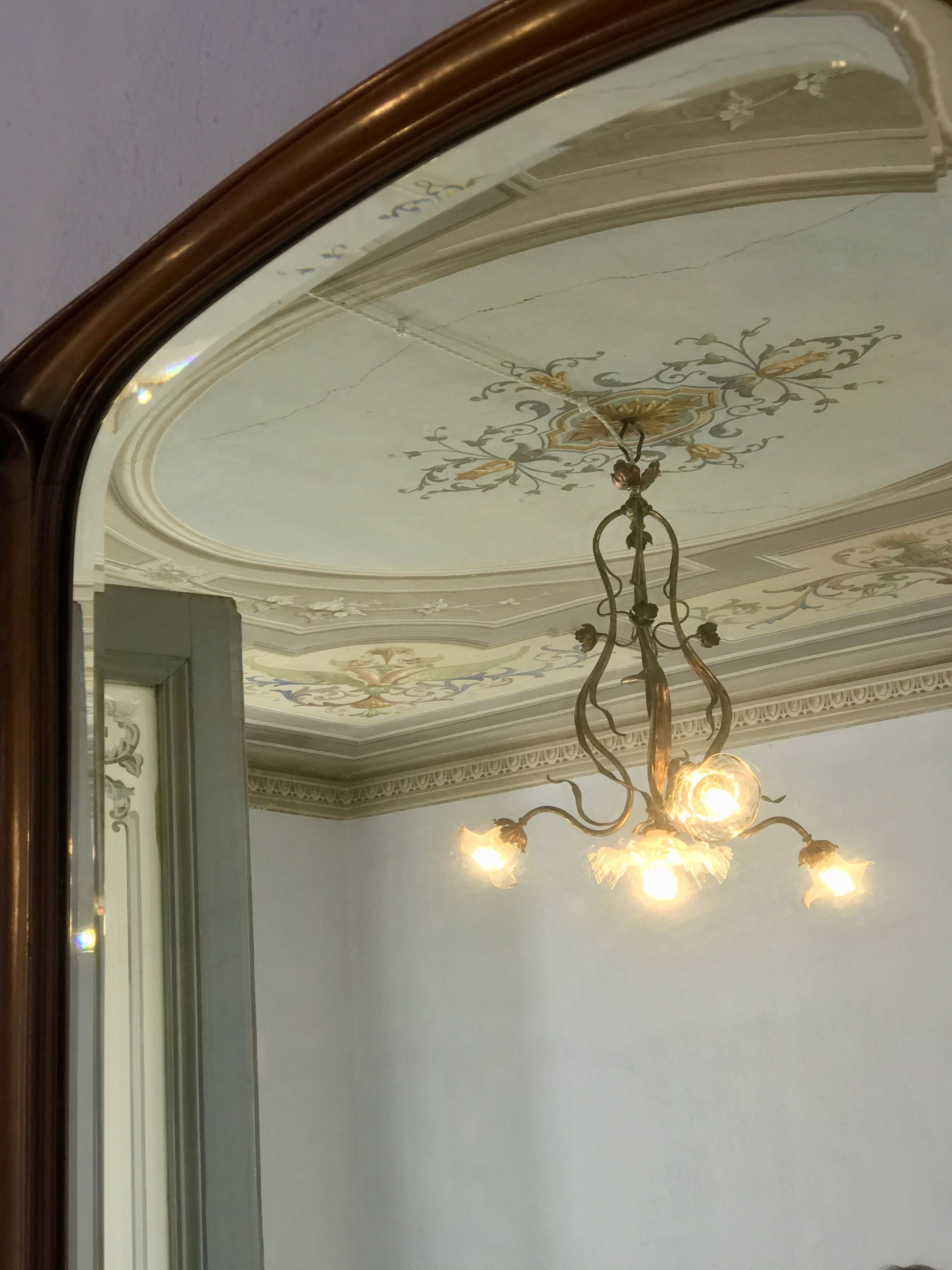 Un lustre doté de plusieurs points lumineux et agrémenté d’un décor ornemental au plafond.