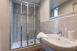 Suite junior, 1 habitación | Baño | Regadera, secadora de cabello, bidet, toallas 