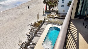 A pool area with a view of the beach, a wooden deck, and a building with a balcony. - Oceanfront Oasis - 2 Bedroom, 2 Bath Beautifully Renovated Oceanfront Condo (Garden City Beach)