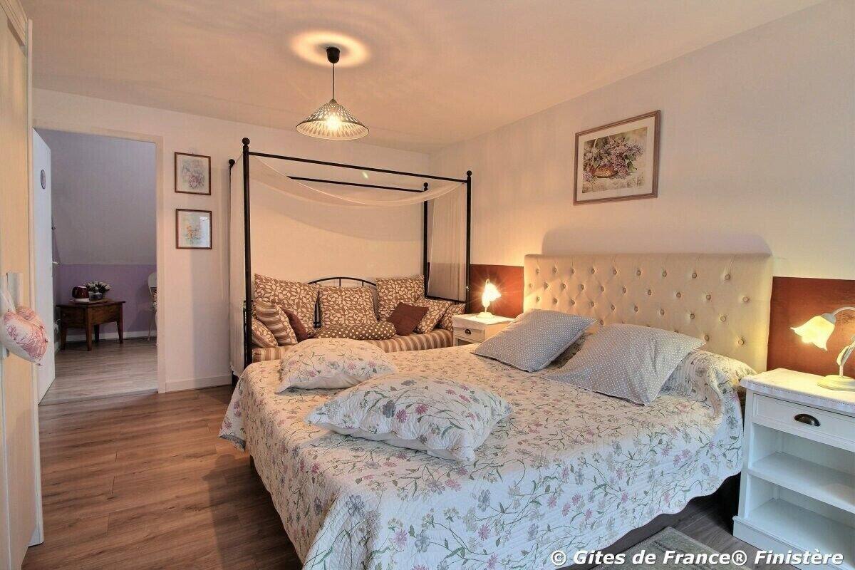 A bedroom with a four-poster bed, bedside lamps, and a nightstand.