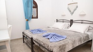 A bedroom with a bed, a chair, and a small table. - Bella Vita Style rooms & apartments-Incanto (Pitsidia)