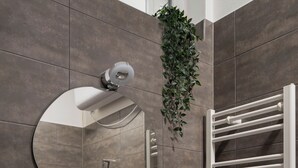 A bathroom with a white sink, a mirror, and a towel rack. - Apartment Pekarska 29 by goodnite cz (Brno)