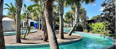 A pool area with palm trees and a clear blue pool.