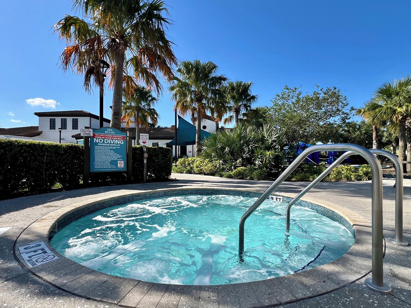 A hot tub with a sign indicating no lifeguard on duty and a maximum depth of 6 feet.