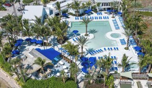 An aerial view of a resort with multiple swimming pools, sun loungers, and palm trees. - SUMMER RATES! OV3 LOCATION! 2 MINUTE WALK TO BEACH PRIME LOCATION TO EVERYTHING! (Fort Pierce)