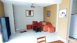 A living room with a sofa, ottoman, coffee table, and a dining table with chairs. - fresh apartment 90 m2,  with huge balcony (Bávaro)
