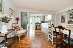 Enjoy a meal in the dining area with a table and chairs, surrounded by a sideboard and a vase with flowers.