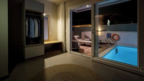 A modern room with a sliding glass door leading to a balcony with a pool. - Sarpidon Suites (Chania)