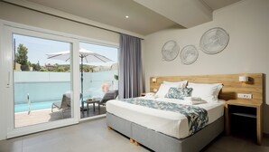 A modern bedroom with a large bed, a sliding glass door to a balcony, and decorative wall art. - Sarpidon Suites (Chania)